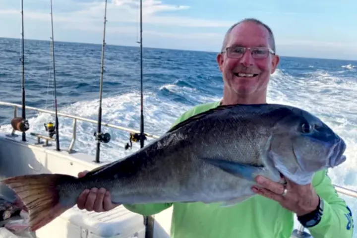a man holding a fish in the water