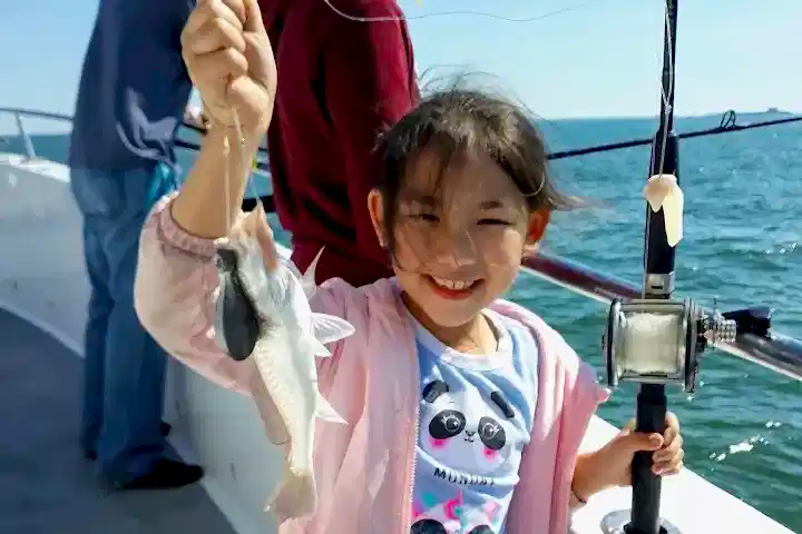 a little girl holding a fish