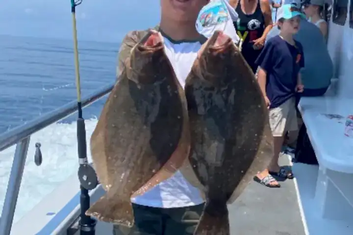 a man holding a fish on a boat