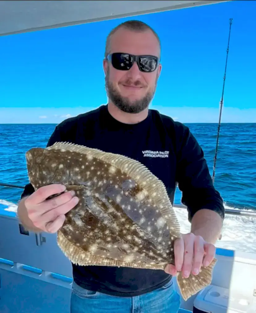 bob_flounder a person holding a fish in the water